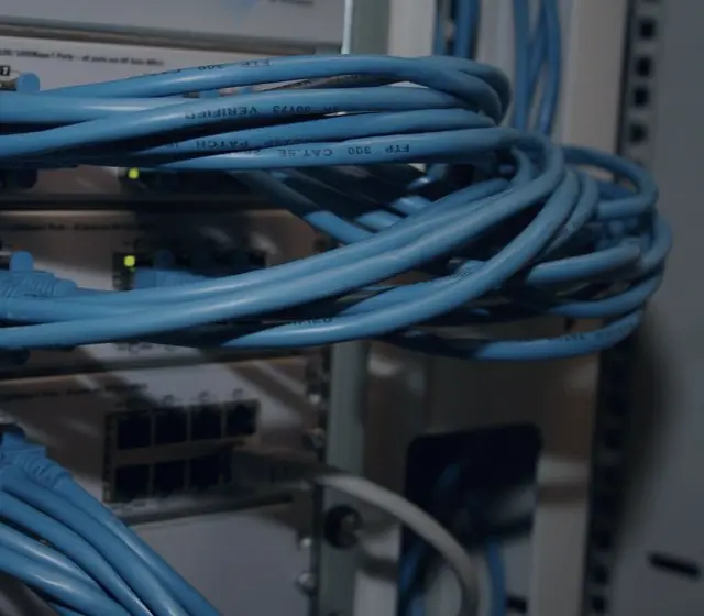 Cables de red azules peinados y organizados sobre switches en un rack